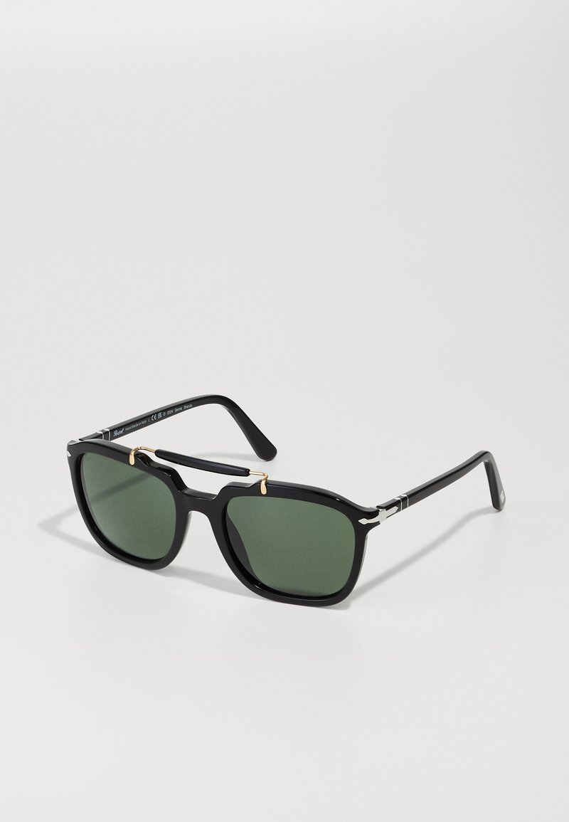 Black square sunglasses with green lenses, gold accent between lenses, and silver detailing on arms. Made of lightweight plastic material.