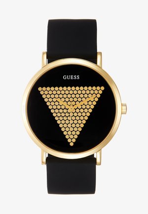 Sort klokke med en rund gullcase, som har et trekantet gullprikkemønster på en svart urskive. Silikonremmen sikrer holdbarhet.