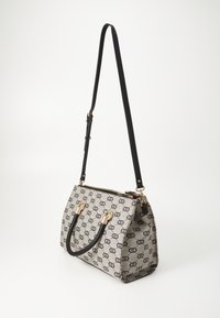 Gray fabric handbag with black circular patterns, gold hardware, dual black handles, and adjustable strap. Zippered top closure.
