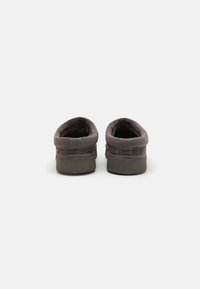 Gray fabric slip-on shoes with a soft, textured finish. Rounded back, low-profile rubber outsole, and minimalistic design.