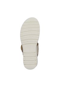 Suela de un zapato, de goma blanca con un patrón de agarre texturizado. Presenta una parte superior de un tono claro, costuras reforzadas y una plantilla acolchada.