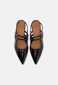 Black patent leather slingback shoes with pointed toes, featuring two adjustable straps and a smooth brown insole.