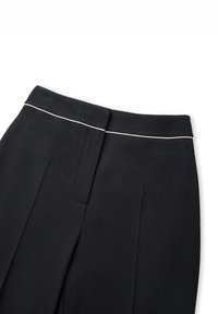 Zwarte broek met een gladde textuur, een dunne witte bies langs de tailleband en twee plooien voor extra ontwerpelementen.