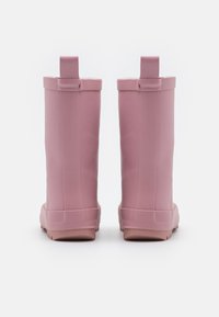 Bottes de pluie en caoutchouc rose avec un design haut, un sommet arrondi et des languettes en boucle à l'arrière. Semelle texturée pour une bonne adhérence et une stabilité.