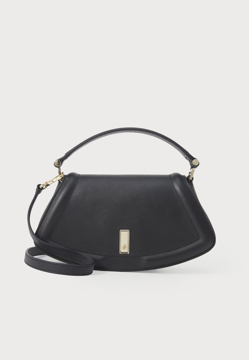 Μαύρη δερμάτινη τσάντα χεριού με δομημένο σχήμα, διαθέτοντας κοντό χερούλι και αποσπώμενο λουρί, διακοσμημένη με λεπτομέρεια κλεισίματος σε χρυσή απόχρωση.
