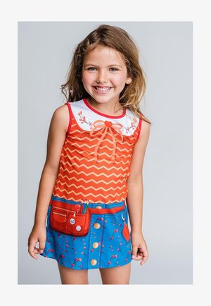 Haut sans manches orange à motif zigzag avec col blanc, nœud rouge et détails floraux ; jupe bleue avec poche et boutons, ornée d'un motif floral.