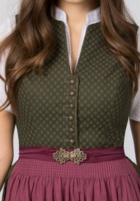 Traditionelles Kleid mit einem dunkelgrünen, gemusterten Oberteil mit Knöpfen, ergänzt durch einen burgunderroten, plissierten Rock und einer dekorativen, metallischen Gürtelschnalle.