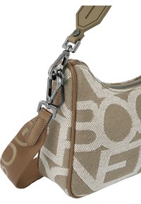 Sac à main designer beige avec un extérieur en toile à motifs, une fermeture éclair en argent, et une bandoulière ajustable avec des accents de logo. Bord en cuir lisse.