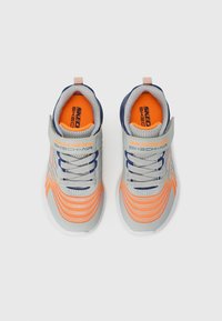 Baskets de sport grises avec des accents orange et des détails marine. Dotées d'une tige en maille, de lacets élastiques et d'une sangle Velcro pour un ajustement sécurisé.