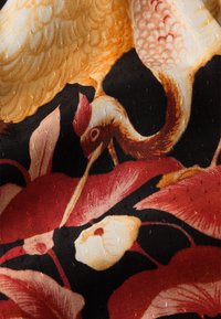 Mehrfarbiger Stoff mit detaillierten Blumemustern in Rot und Creme, mit goldenen Kranichen auf schwarzem Hintergrund und strukturierten Oberflächen.