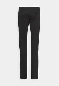 Pantalons de sport noirs en tissu extensible, avec une texture lisse, une coupe slim et un petit logo à l'arrière de la taille.