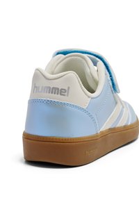 Niebiesko-biały but sportowy z paskiem na rzep, gładką syntetyczną cholewką, teksturowaną gumową podeszwą i srebrnym logo.