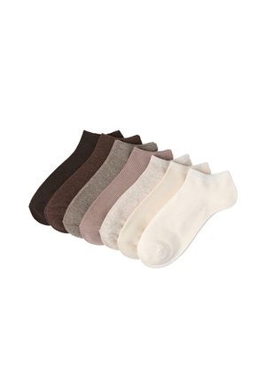 Sept paires de chaussettes basses disposées côte à côte dans différentes couleurs neutres allant du brun foncé au blanc cassé sur un fond blanc.