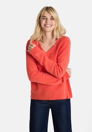 Korallenfarbener Strickpullover mit V-Ausschnitt, langen Ärmeln und gerippten Bündchen. Verfügt über ein kleines, pinkes Logo am Saum. Weicher Stoff.