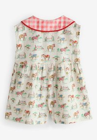 Bezroku zīdaiņu kombinezons ar rozā rūtainu apkakli un zirgu, zirgu seglu un jāšanas šķēršļu attēlojumu uz krēmkrāsas fona.