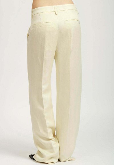 Pantalones de pierna ancha en tela amarilla clara, con dos bolsillos traseros, una textura suave y un corte relajado que cae de manera elegante.