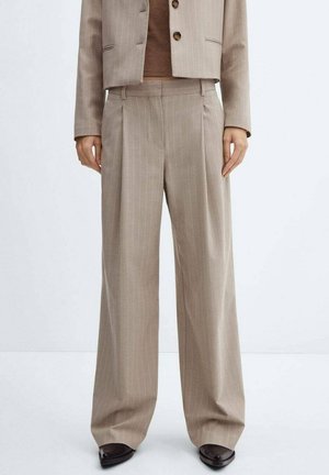 Beige Nadelstreifenweite Hosen kombiniert mit einem passenden kurzen Blazer und dunkelbraunen Schuhen auf neutralem Hintergrund.