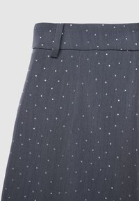 Gonna di tessuto grigio con una superficie liscia, caratterizzata da un motivo sparso di piccole paillettes blu lucide e una cintura piatta.