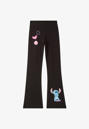 Pantaloni neri con stampe di cartoni animati rosa e blu, abbinati a una maglietta bianca a maniche lunghe. Il tessuto è morbido e la vestibilità è comoda.