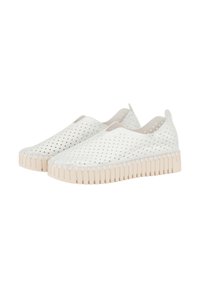 Zapatillas blancas sin cordones con un patrón superior perforado, que cuentan con una suela beige texturizada y un diseño de puntera redondeada.