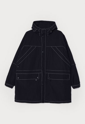 Giacca con cappuccio in navy realizzata in tessuto leggero, con cuciture bianche ben visibili, due tasche frontali e lacci regolabili sul cappuccio.
