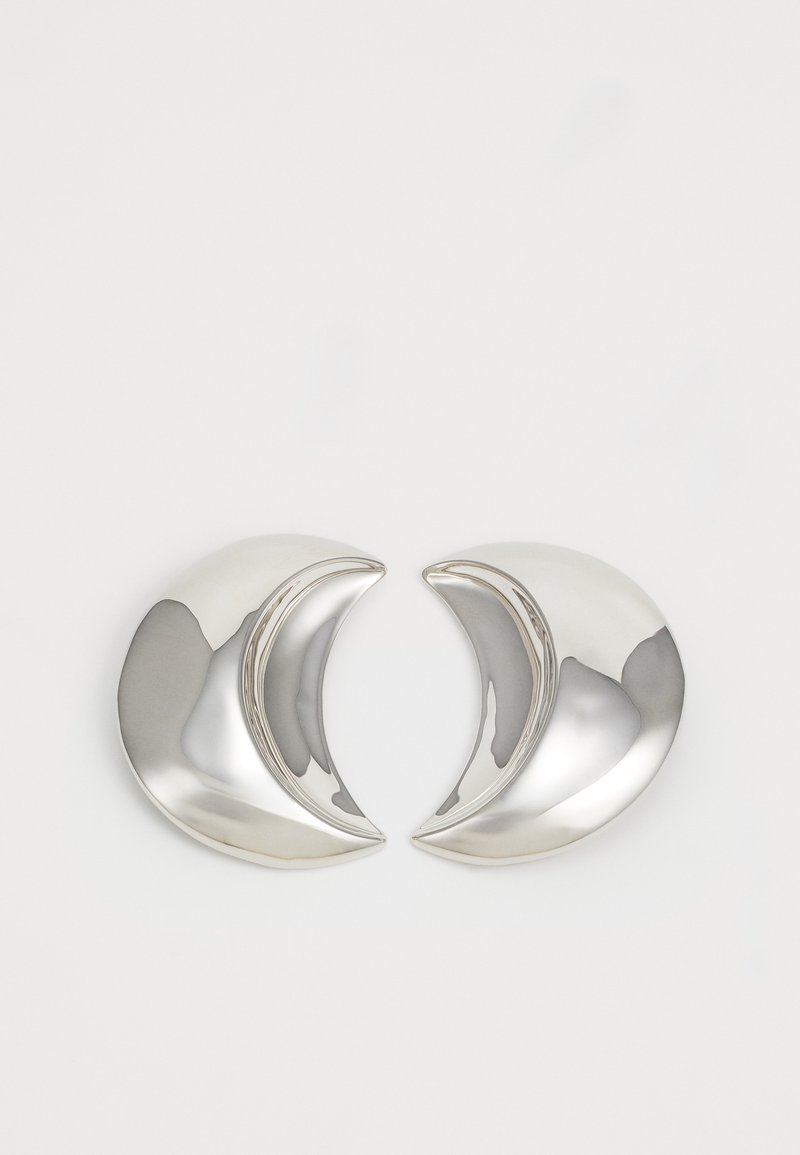 Boucles d'oreilles en argent en forme de croissant avec une finition polie, présentant des courbes lisses et des surfaces réfléchissantes, créant un design moderne et élégant.