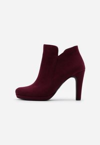Burgundské semišové kotníkové boty s špičatou špičkou, zakřiveným výřezem a vysokým jehlovým podpatkem; elegantní silueta a hladký povrch.