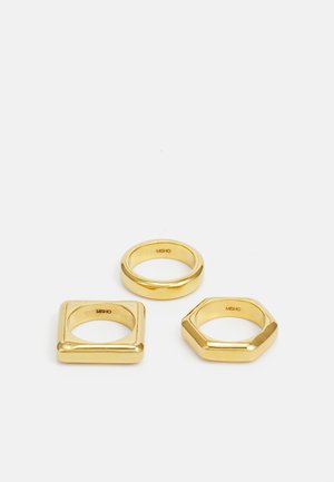 Conjunto de tres anillos de oro: uno redondo, uno cuadrado y uno hexagonal. Superficie lisa con un acabado pulido, mostrando formas geométricas.