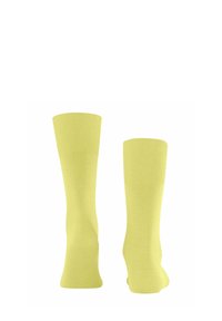 Żółte skarpetki do kolan wykonane z gładkiego materiału z żebrowanymi mankietami. Projekt charakteryzuje się jednolitym kolorem bez wzorów ani akcentów.