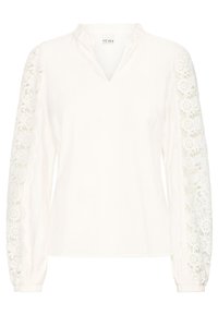 Blusa bianca con scollo a V, in tessuto testurizzato, e maniche lunghe con dettagli in pizzo intricato lungo i lati esterni.
