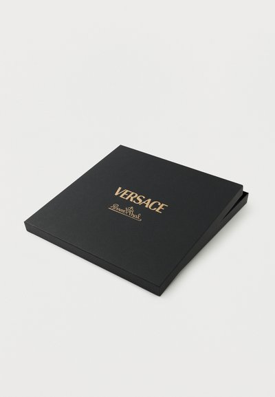 Μαύρο τετράγωνο κουτί της Versace Rosenthal με καπάκι ελαφρώς ανοιχτό σε λευκό φόντο.