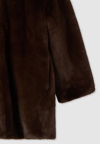 Cappotto in finta pelliccia marrone con una finitura morbida e texturizzata. Presenta una vestibilità ampia e maniche larghe. Il materiale ha un aspetto soffice e una texture liscia.