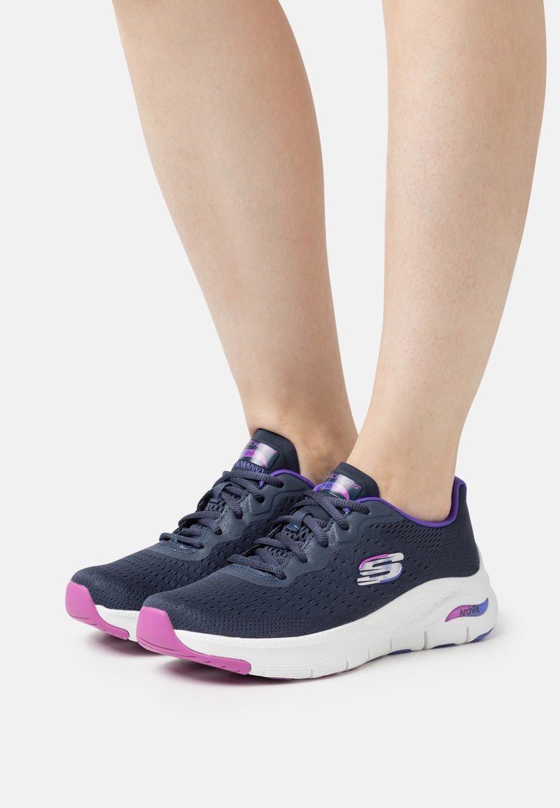 Navy mesh sneakers with purple accents and pink rubber soles. Features a textured upper, padded collar, and lacing system.