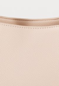 Light pink leather bag with a textured finish and smooth upper edge. Stitched detailing enhances durability.