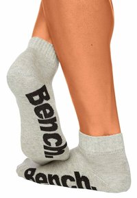 Hellgraue Baumwollsocken mit schwarzem "Bench."-Logo, ausgestattet mit einem gerippten Saum und glatter Textur, die für Komfort und Passform ausgelegt sind.
