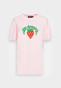 T-shirt de algodão rosa com mangas curtas e decote redondo, estampada com o texto verde "day dreaming" e um gráfico de um morango vermelho.