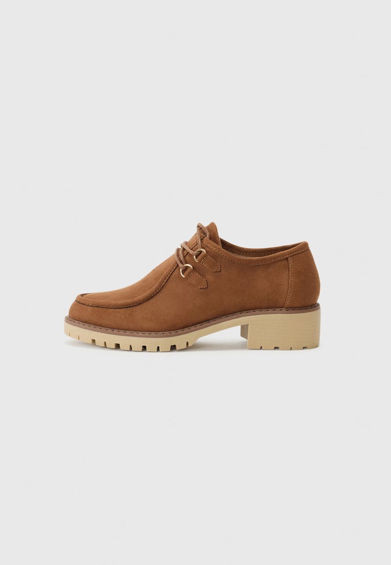 Chaussures en suède marron à lacets avec un bout arrondi, dotées d'un talon épais beige et d'une semelle texturée pour une meilleure adhérence.