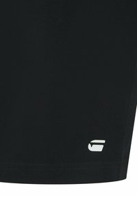 Schwarze Sportshorts aus glattem Material mit einem weißen Logo am Saum und seitlichen Einsätzen in kontrastierender Textur.