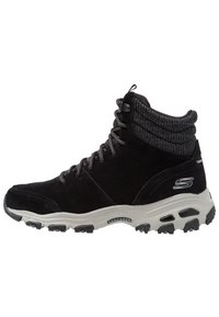 Czarne zamszowe sneakersy w średnim kroju z szarym dzianinowym kołnierzem, sznurowanym przodem i amortyzowaną podeszwą. Wyposażone w teksturowane akcenty i logo Skechers.