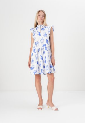 White dress with blue shell and leaf patterns, ruffled short sleeves, round neckline, tiered skirt, paired with beige open-toe heels.