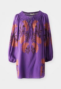 Blouse violette avec un col froncé, des manches bouffantes longues et une broderie florale orange. Tissu léger avec une texture fluide.