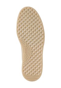 Suola di scarpa in gomma color avorio, caratterizzata da una superficie testurizzata con moduli triangolari in rilievo e un logo circolare vicino al tallone.