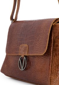 Bruine leren handtas met een textuur van krokodillenpatroon. Voorzien van een klep sluiting, metalen logo accent en een enkele verstelbare schouderband.