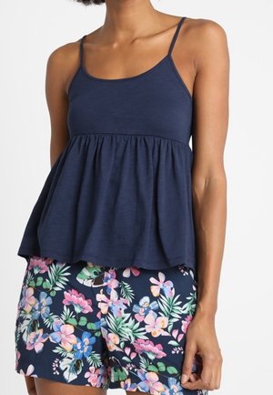 Navy blue sleeveless top with a gathered peplum design, paired with floral print shorts featuring pink, green, and blue accents.