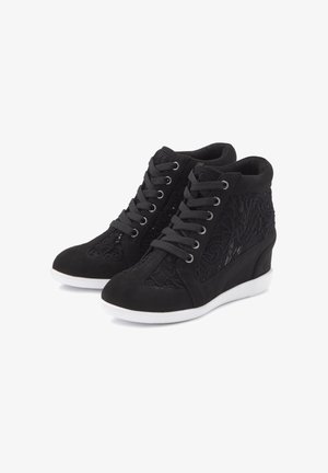 Black wedge sneakers featuring a combination of suede and lace detailing, with flat laces and a rubber outsole. Textured and patterned accents.