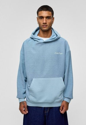 Lichtblauwe hoodie in textuurstof, met een voorzak en geborduurd logo. Ruime pasvorm met geribde manchetten.