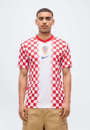 Mann trägt ein rot-weiß kariertes kroatisches Fußballtrikot mit HNS-Emblem und Nike-Logo, kombiniert mit beigen Cargo-Shorts.