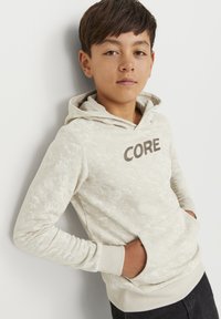 Světlé béžové mikina s texturovaným vzorem, klokankou a nápisem "CORE" v tmavě hnědé barvě. Disponuje stažením na kapuci a žebrovanými manžetami.