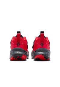 Czerwone trampki z fakturowaną cholewką, czarnymi akcentami oraz śródstopiem z szaro-czerwoną wzorzystą podeszwą. Wyposażone w pętelkę na pięcie.