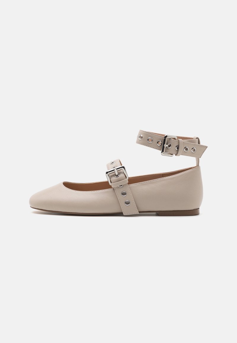 Ballerine beige avec un bout pointu, bride de cheville comprenant du matériel en argent, et une texture en cuir lisse. Semelle plate au design minimal.